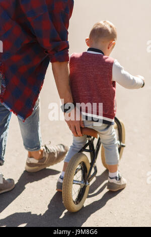 Papà insegna figlio di cavalcare Foto Stock