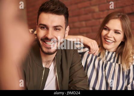Happy amici avente riuniti in ambienti interni Foto Stock