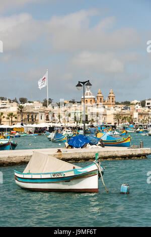 Tradizionale Maltese barche da pesca o luzzu, dipinto luminosamente nel porto di Marsaxlokk a Malta Foto Stock