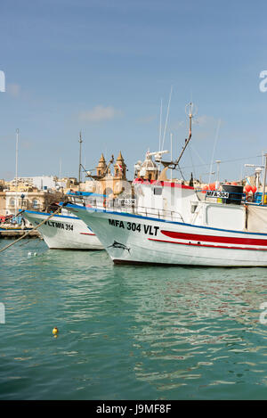 Tradizionali barche da pesca maltesi dipinto luminosamente nel porto di Marsaxlokk a Malta Foto Stock