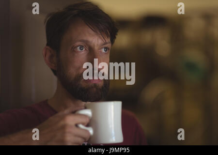 Considerato proprietario azienda tazza di caffè presso officina biciclette Foto Stock