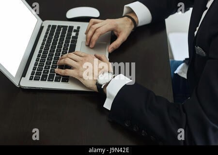 Immagine ritagliata di un giovane uomo che lavora sul suo computer portatile , vista posteriore del business man mani occupato utilizzando il portatile in ufficio, giovane studente maschio digitando su co Foto Stock
