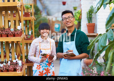 Foto di due giovani cinesi fioraio di lavoro nel negozio Foto Stock