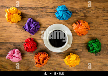 Bianco tazze di bevande calde su pavimento di legno per coffee shop immagine pubblicitaria con carta colorata sfere sopra copyspace sulla zona vuota. Foto Stock