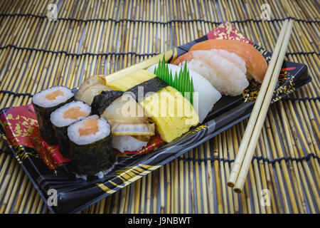 Set di Sushi Sashimi e panini serviti sulla piastra tradizionale e il tappetino Foto Stock