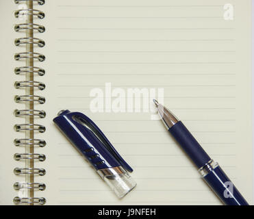 Penna blu su notepad con spirale per memo, nota, scrivere, disegnare, testo e foto Foto Stock