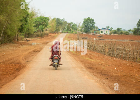 Un giovane in sella a una moto-scooter nei pressi di Pindaya, Myanmar. Foto Stock