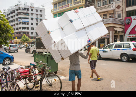 Un giovane uomo che porta una grande cosa. Lanmadaw Township, Yangon, Myanmar. Foto Stock