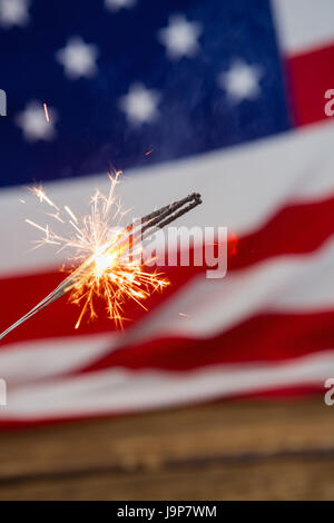 Close-up di botti burning contro la bandiera americana sfondo Foto Stock