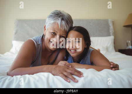 Nonna e nipote rilassante sul letto in camera da letto a casa Foto Stock