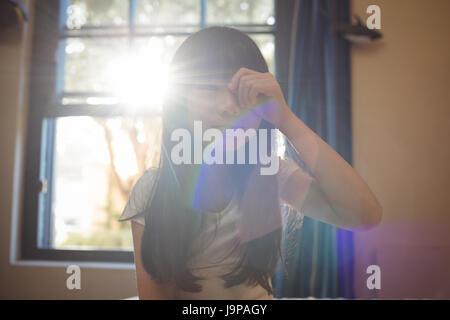 Ragazza di svegliarvi e strofinando gli occhi in camera da letto a casa Foto Stock