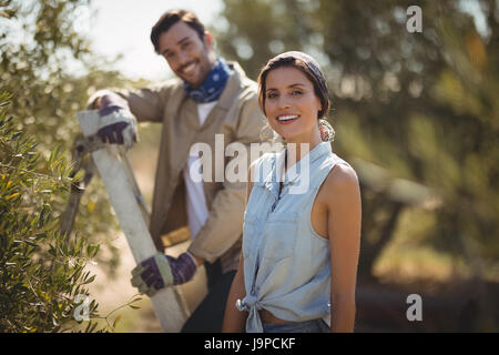 Ritratto di felice coppia giovane in piedi da alberi di olivo agriturismo Foto Stock