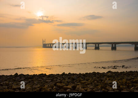 Il Principe di Galles ponte (seconda Severn Crossing) durante un vago il tramonto del Severn Estuary visto dal Severn Beach, Gloucestershire, Inghilterra. Foto Stock
