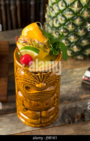 Freddo rinfrescante Tiki bere cocktail con ananas Cherry Orange contorni Foto Stock