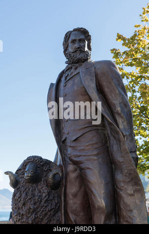 Queenstown, Nuova Zelanda - 15 Marzo 2017: closeup di bronzo scuro statua di William Gilbert Rees, fondatore della città, nel centro cittadino contro il cielo blu con alcuni Foto Stock