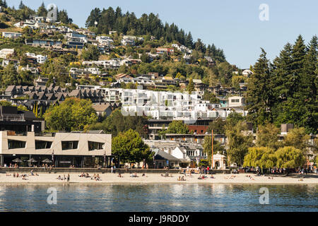 Queenstown, Nuova Zelanda - 15 Marzo 2017: la spiaggia di sabbia nel centro cittadino sulla sponda nord-est del Lago Wakatipu. In stile Riviera ad alta densità abitativa costruita sul pendio di Foto Stock