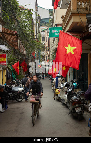 Vicolo occupato e bandiere vietnamita in occupato il quartiere vecchio, Hanoi, Vietnam Foto Stock