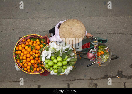 Venditore ambulante con round cesti di frutta sulla bicicletta, il vecchio quartiere di Hanoi, Vietnam Foto Stock