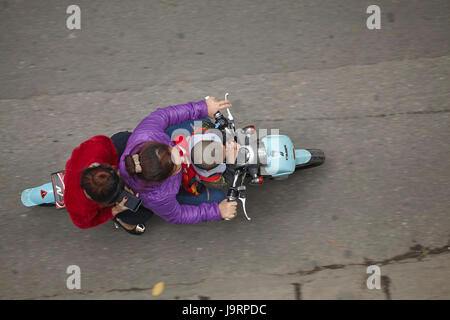 Famiglia su di uno scooter, il vecchio quartiere di Hanoi, Vietnam Foto Stock