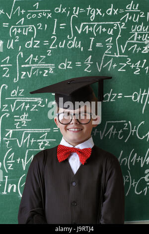 Aule,scuola per bambini,cappuccio di dottorato,supporto,Scuola scheda nero,equazioni,orgogliosamente,mezza ritratto, Foto Stock