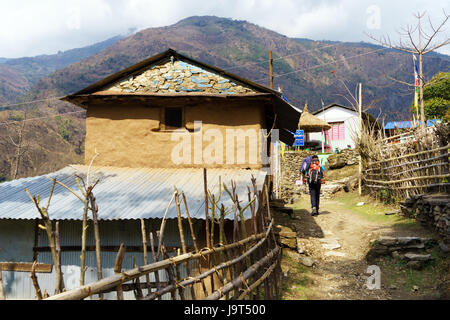 Trekker attraversando il villaggio di Bahundanda, Lamjung distretto, Nepal. Foto Stock