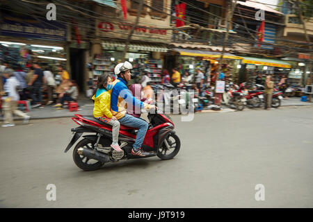 Padre e figli su scooter, il vecchio quartiere di Hanoi, Vietnam Foto Stock