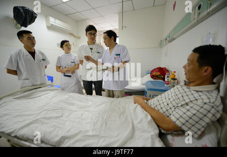 (170603) -- YICHANG, 3 giugno 2017 (Xinhua) -- chirurgo Mei Changqing (seconda R) vede un paziente presso il popolo del Ospedale di Zigui County, centrale cinese della provincia di Hubei, 3 giugno 2017. Mei Changqing è uno tra quelli che hanno beneficiato della ripresa del collegio ingresso esame nel 1977. Il chirurgo, essendo un typesetter nel 1976 dopo la laurea dalla High School, alterato il suo destino prendendo il collegio ingresso esame nel 1977 e fu arruolato da Yichang Medical School. Essendo stato impegnato in medicina clinica per 30 anni, Mei Changqing è orgogliosa della sua scelta. (Xinhua/Lei Yong) (lfj) Foto Stock