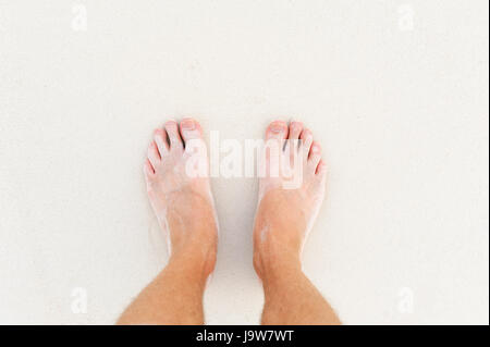 L uomo per le gambe sulla sabbia bianca oceano Indiano Foto Stock