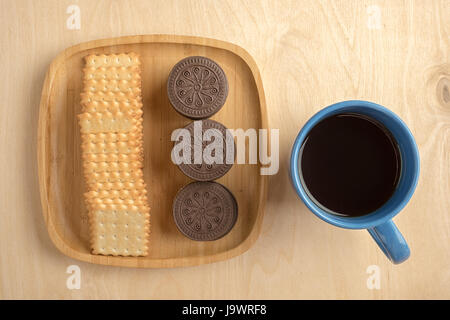 Biscuit cracker sul piatto di legno con una tazza Foto Stock