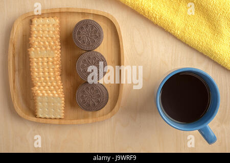 Biscuit cracker sul piatto di legno con una tazza Foto Stock