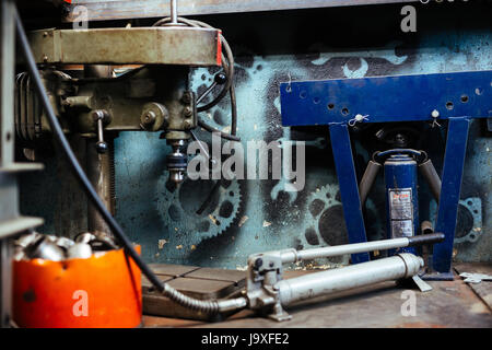 Immagine di sfondo delle varie attrezzature sul pavimento in officina meccanica Foto Stock