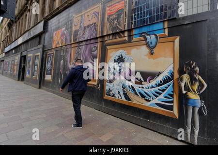 Glasgow public art graffiti commissionato su Argyle street con inserzioni om sito di costruzione per essere demolita per nuovi hotel Foto Stock