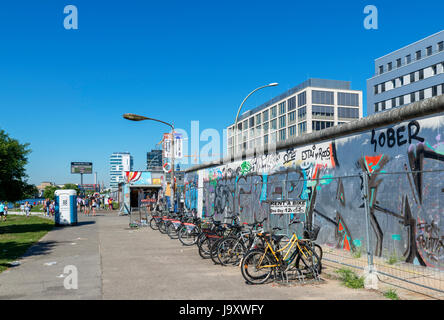 Noleggio di biciclette da una sezione del muro di Berlino all'East Side Gallery, Friedrichshain-Kreuzberg, Berlino, Germania Foto Stock