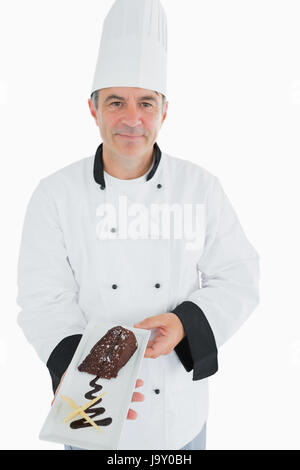 Ritratto di chef maschio offrendo pasticceria cioccolato su sfondo bianco Foto Stock