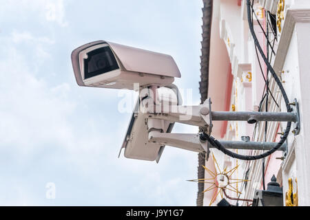 Televisione a circuito chiuso telecamera isolata su un edificio bianco sullo sfondo. Messa a fuoco selettiva Foto Stock