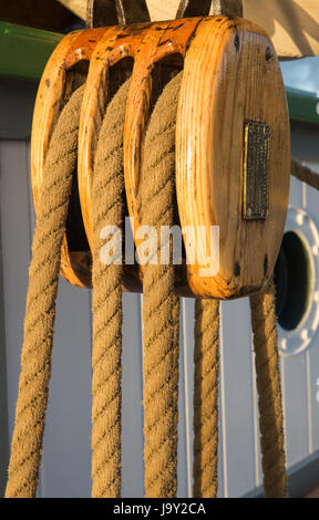 Blocco e affrontare, la puleggia e la corda a bordo di una vecchia nave a vela in tarda serata con una morbida luce dorata Foto Stock