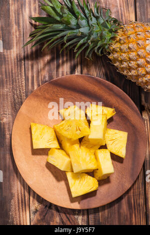 La frutta tropicale concetto. Ananas tagliato sul vecchio sfondo di legno. Foto Stock