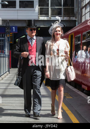 Racegoers a Waterloo, vestito con top hat e code e smart ladies vestito a bordo del treno a Waterloo per l'Epsom Derby Foto Stock