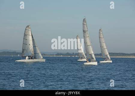 Gruppo di barche a vela di preparazione alla gara su una soleggiata sera primaverile all'ingresso al porto di Chichester Hayling Island. 4 PESCHERECCI IDENTICI. Foto Stock