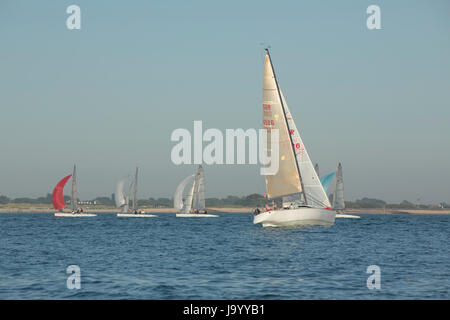 Gruppo di barche a vela di preparazione alla gara su una soleggiata sera primaverile all'ingresso al porto di Chichester Hayling Island. Formare una fila ordinata. Foto Stock