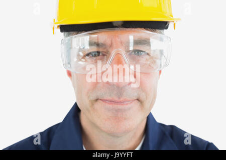 Closeup ritratto di meccanico di indossare casco e occhiali protettivi su sfondo bianco Foto Stock