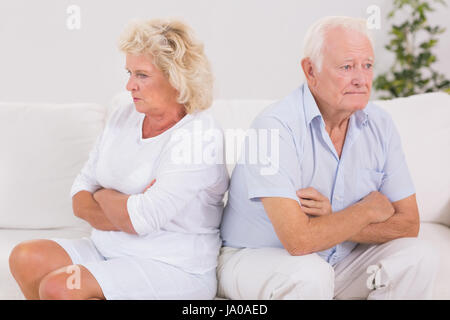 Donna infelice essendo arrabbiato contro un uomo vecchio sul divano Foto Stock