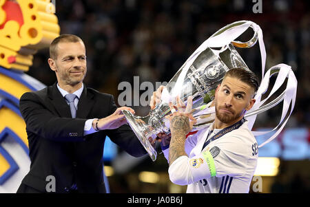 La UEFA Presidente Aleksander Ceferin (sinistra) mani il trofeo al Real Madrid Sergio Ramos (a destra) durante la finale di UEFA Champions League al National Stadium di Cardiff. Foto Stock