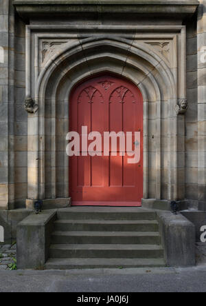 La porta della chiesa in pietra arcuata è circondata da una porta in legno rosso e. scalini di pietra presso la chiesa di tutti i santi si trovano whitefield bury lancashire regno unito Foto Stock