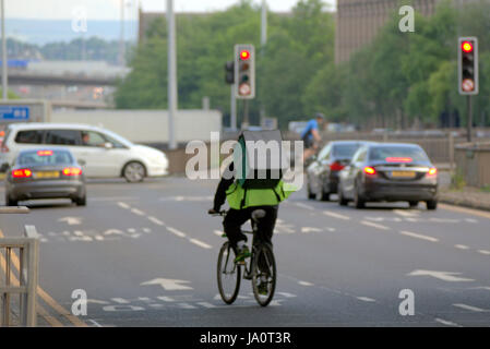 Deliveroo Uber bikers consegna i driver per i ciclisti su strada per somministrare a Glasgow Foto Stock