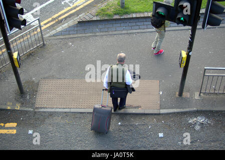 I turisti per le strade di Glasgow in Scozia con trolley ruote Foto Stock