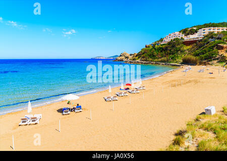 Vista della spiaggia in sabbia di Es Figueral spiaggia con lettini e ombrelloni, isola di Ibiza, Spagna Foto Stock