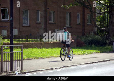 Deliveroo Uber bikers consegna i driver per i ciclisti su strada per somministrare a Glasgow Foto Stock