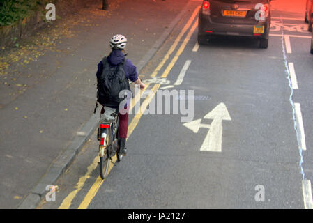 Giovane ragazza in bici ciclista in strada trafficata traffico vicino pista ciclabile e pericolo Foto Stock