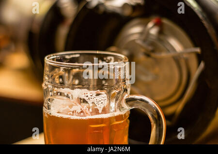 In prossimità di una bionda birra artigianale riempito in una pinta di vetro sul tavolo sfocata Foto Stock